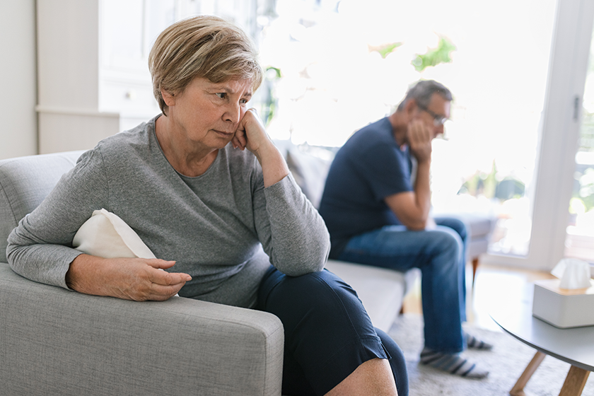 Upset senior couple at home in living room having an argument